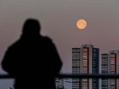 Silhouette of a person stretching against a bright window.